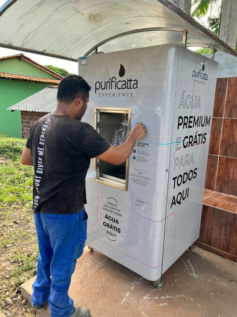 Morador utilizando a máquina com água gratuita para todos