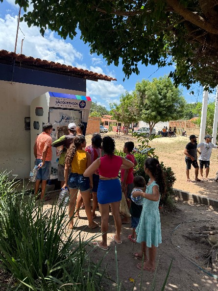 Comunidade utilizando a máquina de água purificada